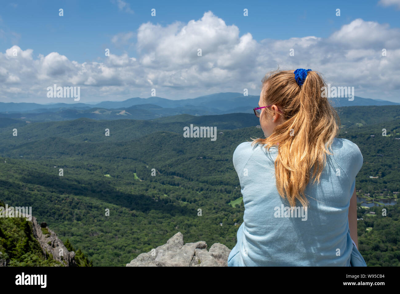 A girl looks out from a rock ledge near the top of Grandfather Mountain
