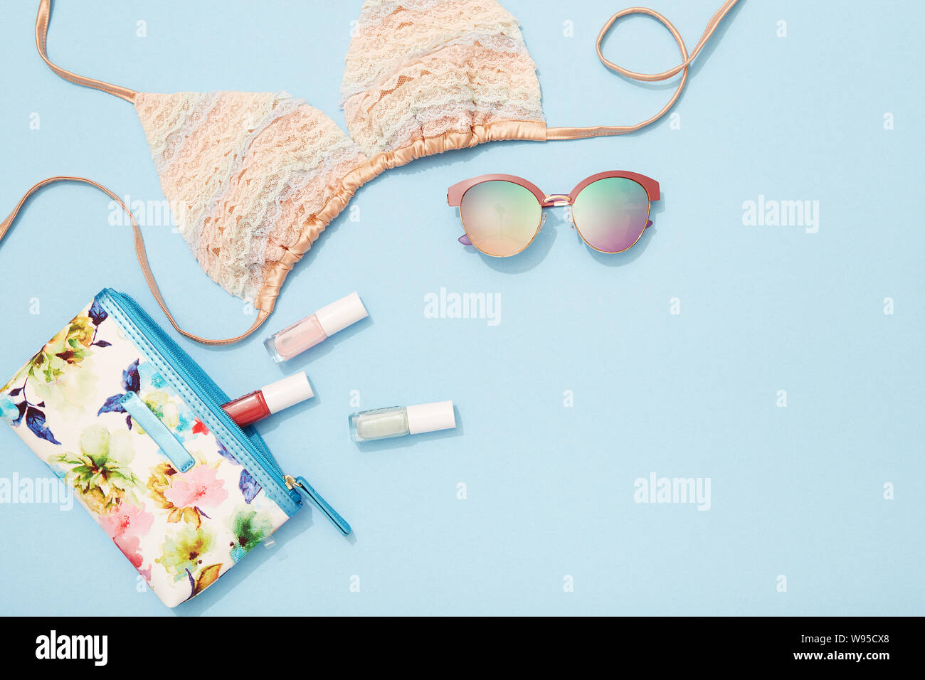 Young woman beach holiday fashion and beauty products and accessories flat lay on blue background Stock Photo