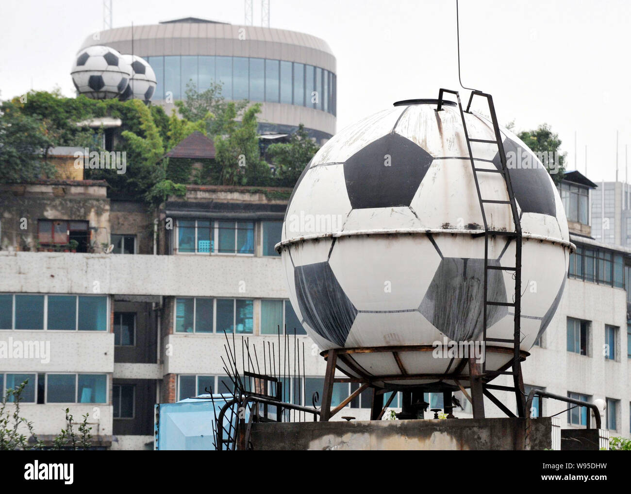 Football-shaped water tanks supplying tap water are pictured on the rooftop of residential apartment buildings in Guiyang city, southwest Chinas Guizh Stock Photo