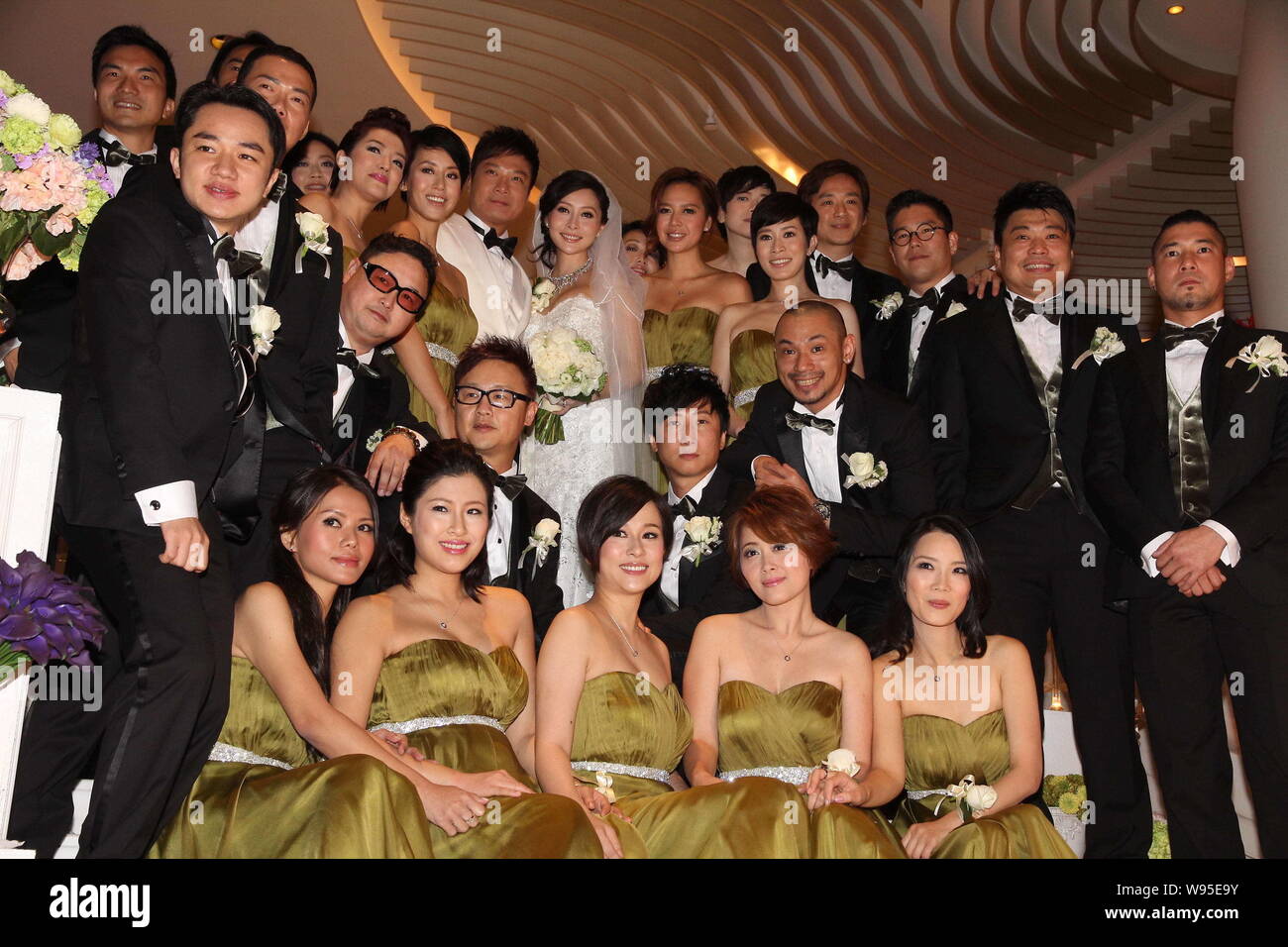Hong Kong actor Chin Ka Lok, center left, and his pregnant actress wife Angela Tong, center right, pose with their groomsmen and bridesmaids during th Stock Photo
