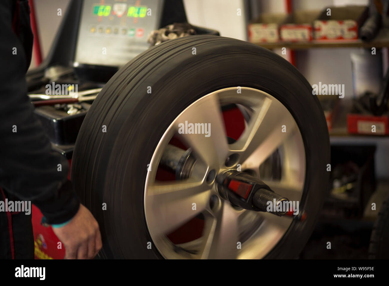 Car tires being changed in garage because of winter season. Workplace environment in dark colors