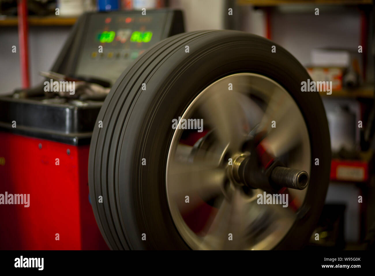 Car tires being changed in garage because of winter season. Workplace environment in dark colors