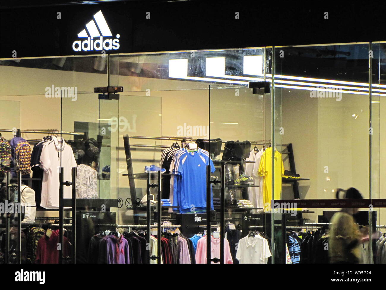 File--A customer shops in an Adidas store in Shanghai, China, 10 April  2011. Adidas AG will aim at niches such as high fashion and childrens wear  Stock Photo - Alamy