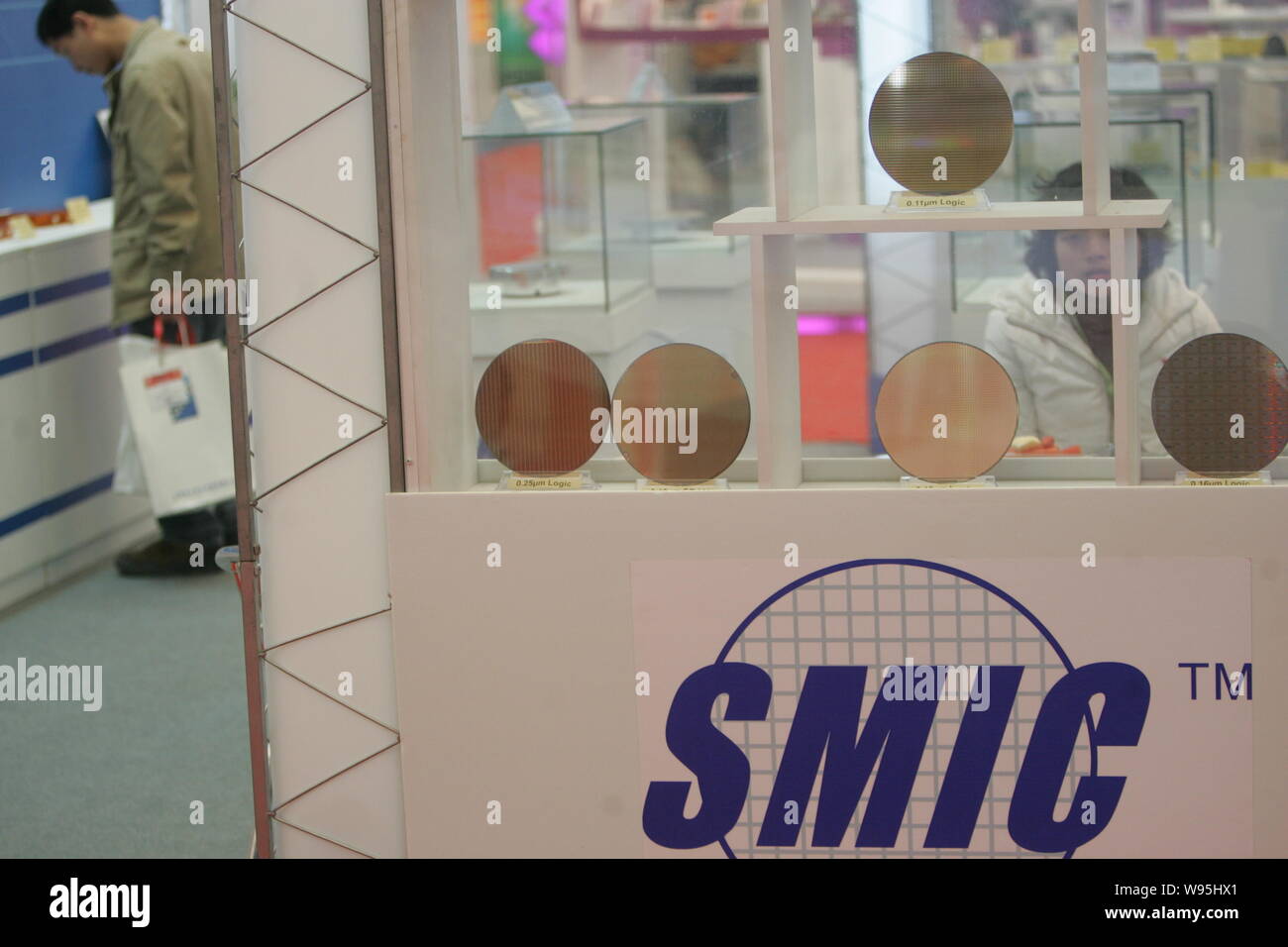 --File--Chinese visitors look at wafers at the booth of SMIC ...