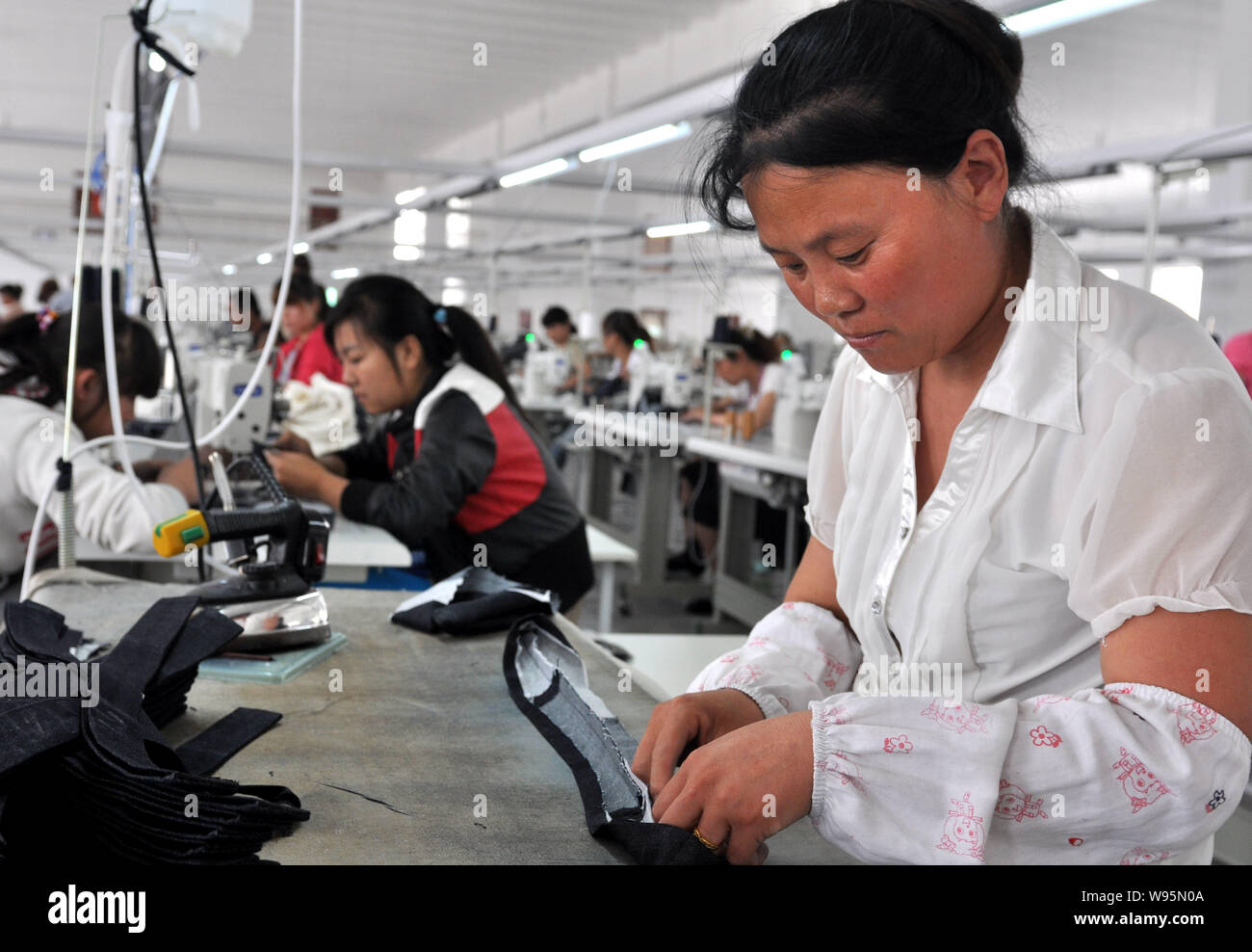 --File--Chinese staff are seen working at a garment factory in Binzhou city, east Chinas Shandong province, 1 June 2012.   Chinas exports and imports Stock Photo