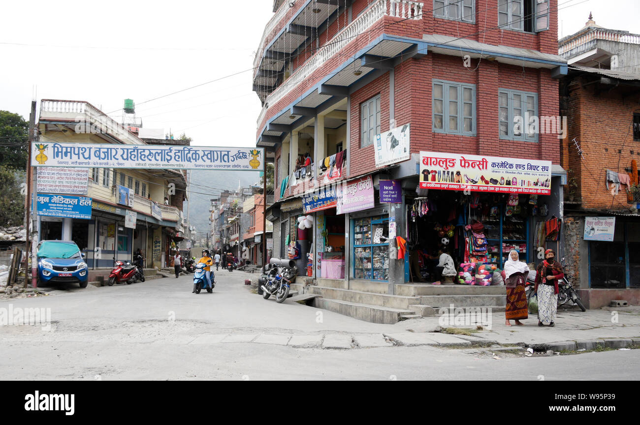 Shops, residences, vehicles, and people on the street in the Old Bazaar area of Pokhara, Nepal Stock Photo
