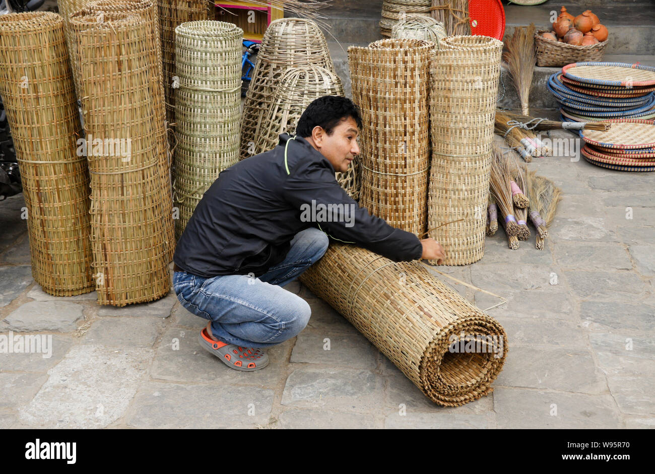 A man sells rattan products in the Old Bazaar area of Pokhara, Nepal Stock Photo