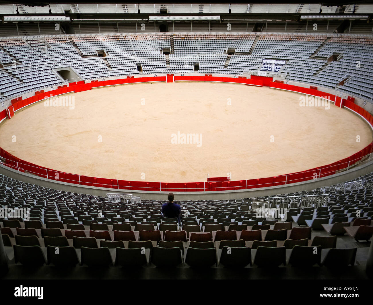 Lone visitor sitting in empty bullfighting arena in Spain. Spanish corrida, traditional cultural event. Animal abuse, cruelty to animals. Animal right Stock Photo
