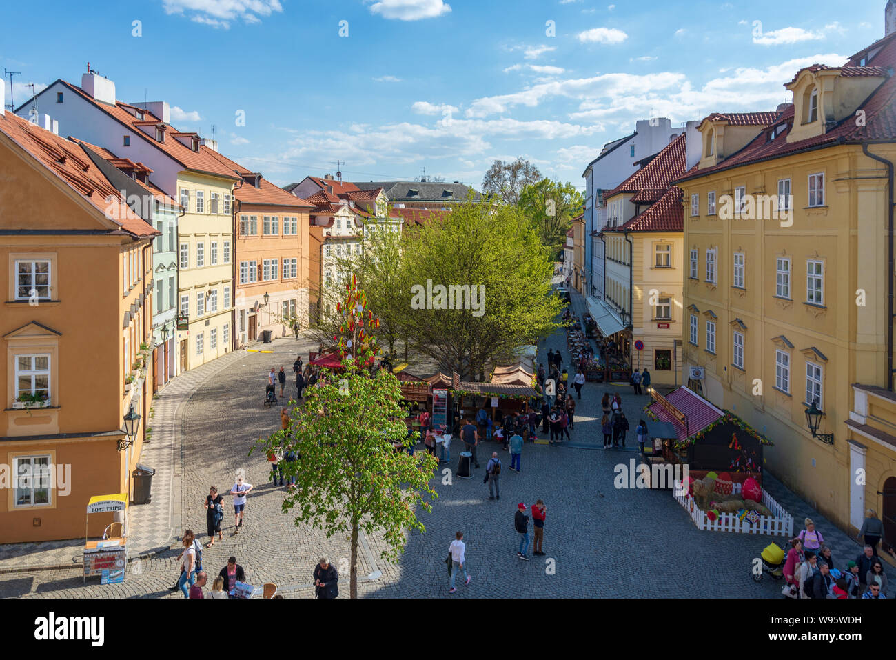View from Charles Bridge of lower temporary market around small plaza at Na Kampě street between colorful typical architectural European style. Stock Photo