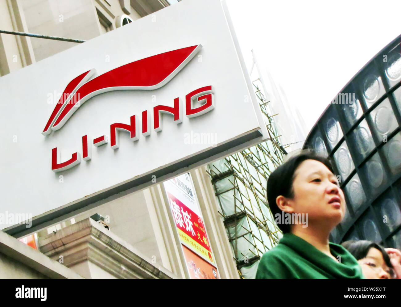 FILE--Pedestrians walk past a Li-Ning sportswear shop in Shanghai, China, 1  October 2011. Li Ning, the largest Chinese sports brand, has been unde  Stock Photo - Alamy