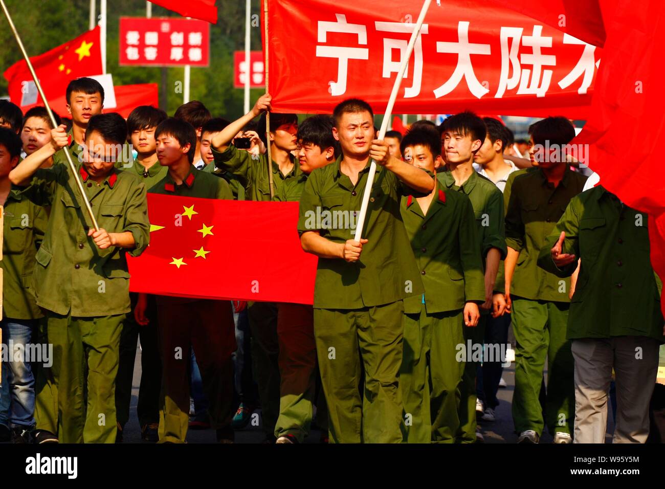 Chinese protestors dressed in the Red Army costumes wave Chinese national flags and hold banners an anti-Japan protest outside the Embassy o Stock Photo - Alamy