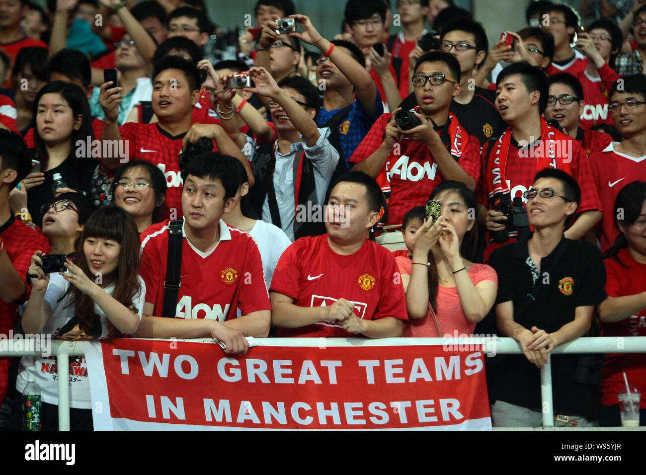 Soccer fans watch players of Manchester United exercising during a training session at the Shanghai Stadium in Shanghai, China, 24 July 2012.   Premie Stock Photo
