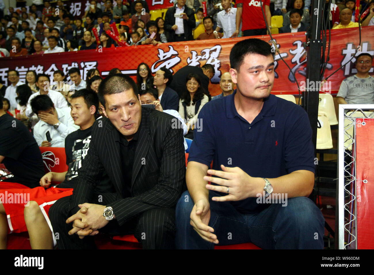 Retired Chinas basketball star Yao Ming (R) and Chinas basketball player Mengke Bateer are pictured during his friends farewell match in Dongguan city Stock Photo