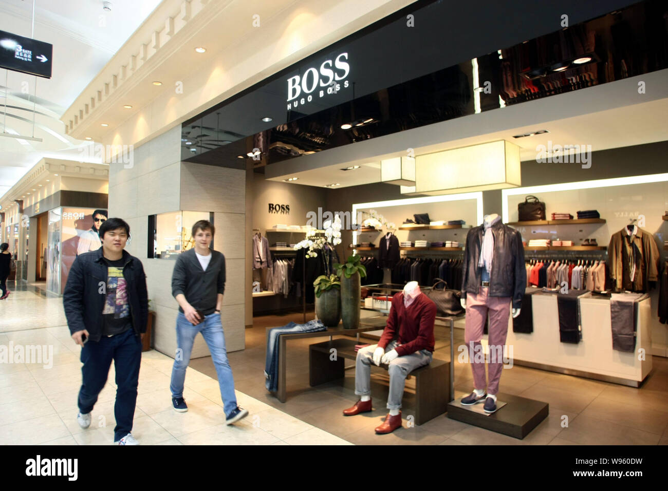 FILE--Shoppers walk past the Hugo Boss boutique at the No.1 Yaohan  Department Store in Pudong, Shanghai, China, 5 April 2012. German high-end  fash Stock Photo - Alamy