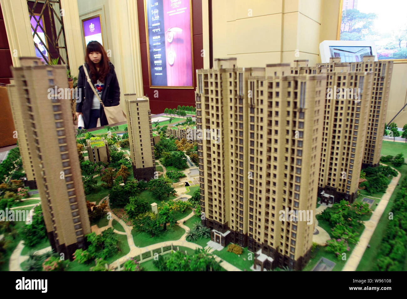 A Chinese homebuyer looks at models of a residential apartment project during the Shanghai Spring Real Estate Trade Fair 2012 in Shanghai, China, 15 M Stock Photo