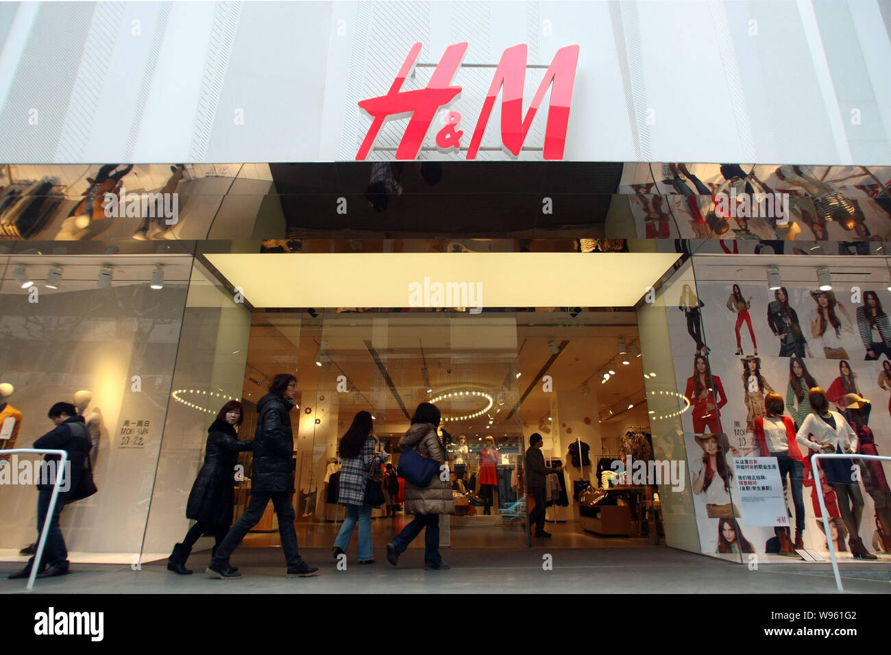 File--Shoppers walk into an H&M store in Shanghai, China, 30 January 2012.  The latest label to join the rush into China is the Spanish clothing gi  Stock Photo - Alamy