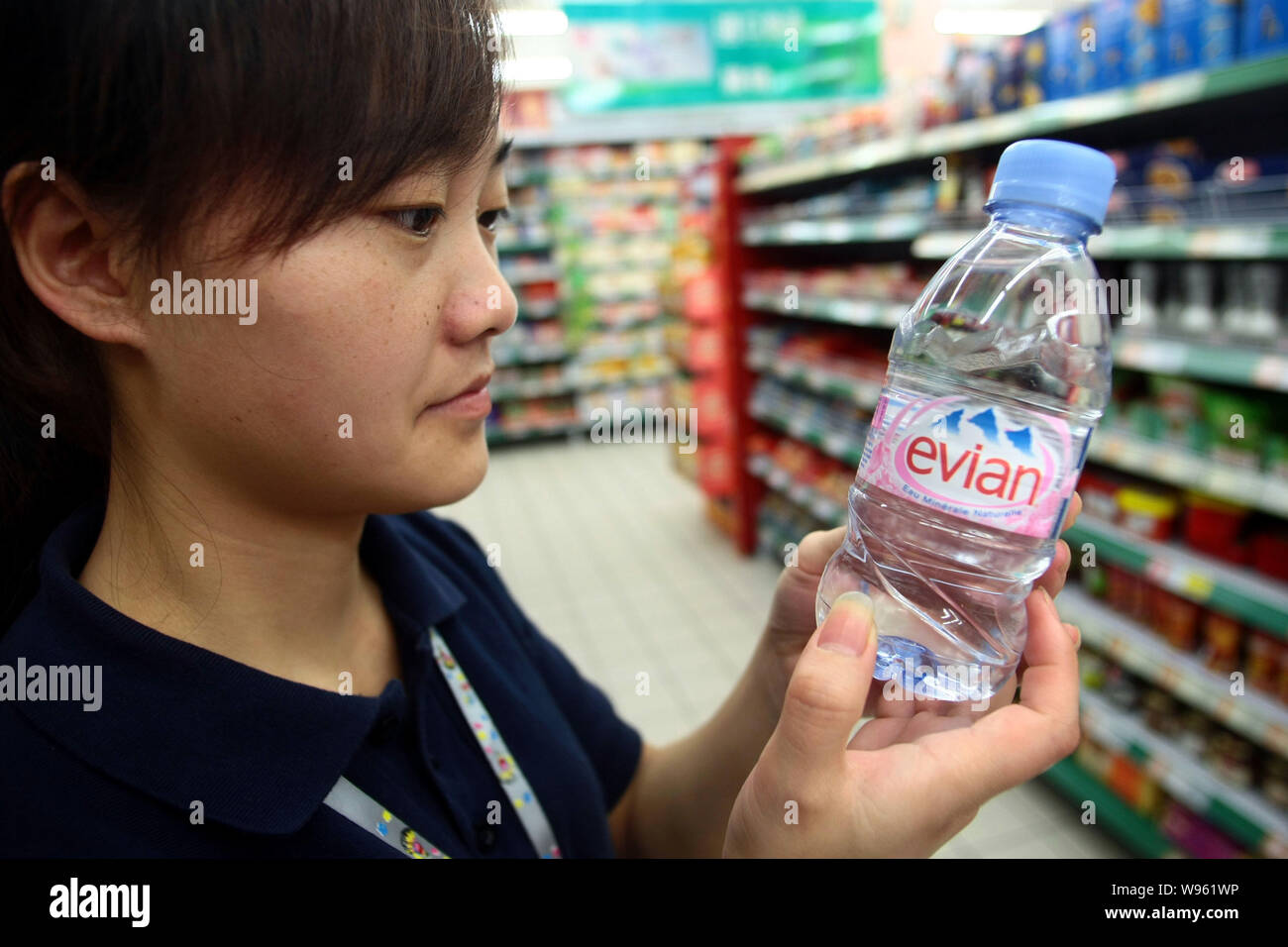 FILEA Chinese staff member checks a bottle of Evian mineral water