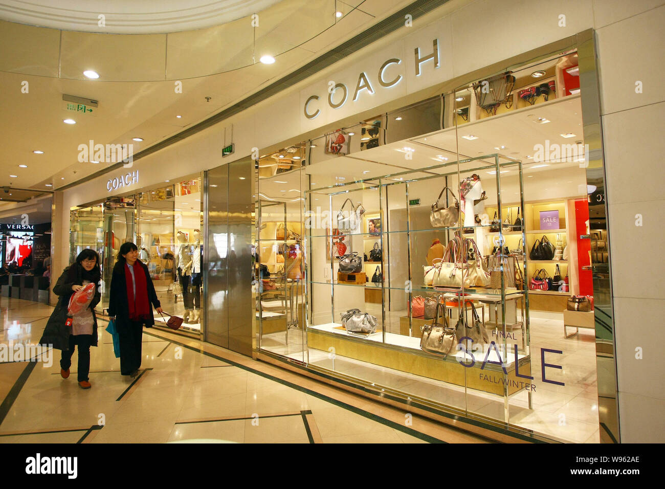 File Customers walk past a Coach boutique at a shopping mall in Shanghai China 11 February 2011. After delivering an outstanding sales report f Stock Photo Alamy