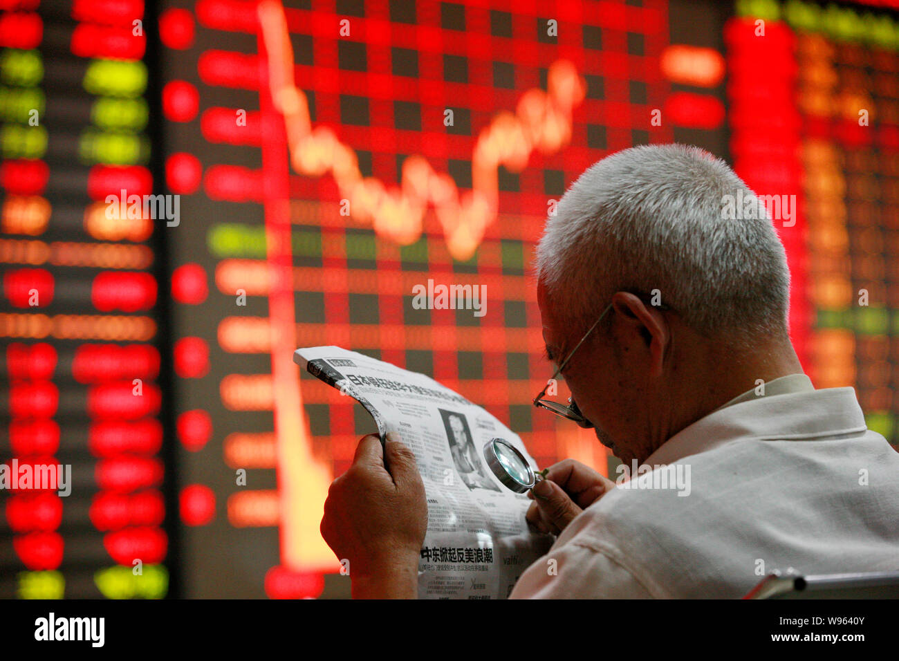 Investors check for stock information at a private securities company in Huaibei, east Chinas Anhui province, 14 September 2012.    The stock markets Stock Photo