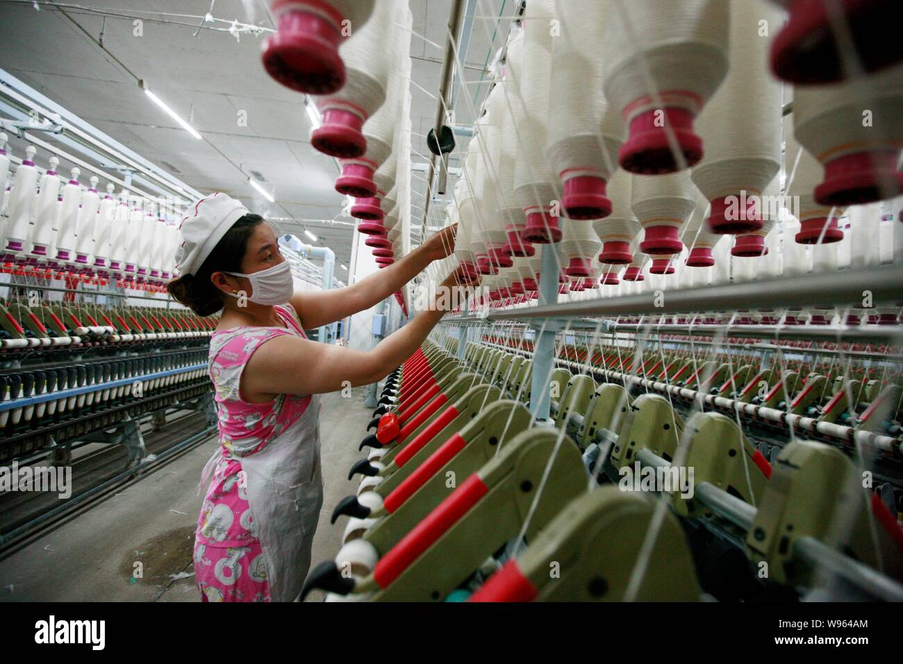 --File--A Chinese staff is seen working at a textile factory in Huaibei city, east Chinas Anhui province, 1 June 2012.   Chinas exports and imports re Stock Photo