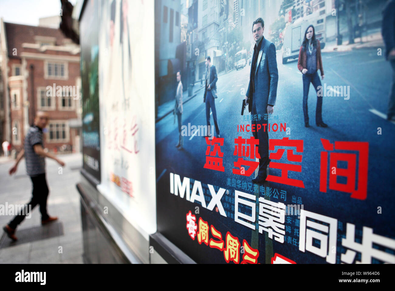 --FILE--A pedestrian walks past a poster of the movie, Inception, with the signage of IMAX at a cinema in Shanghai,  China, 7 September 2010.   A year Stock Photo