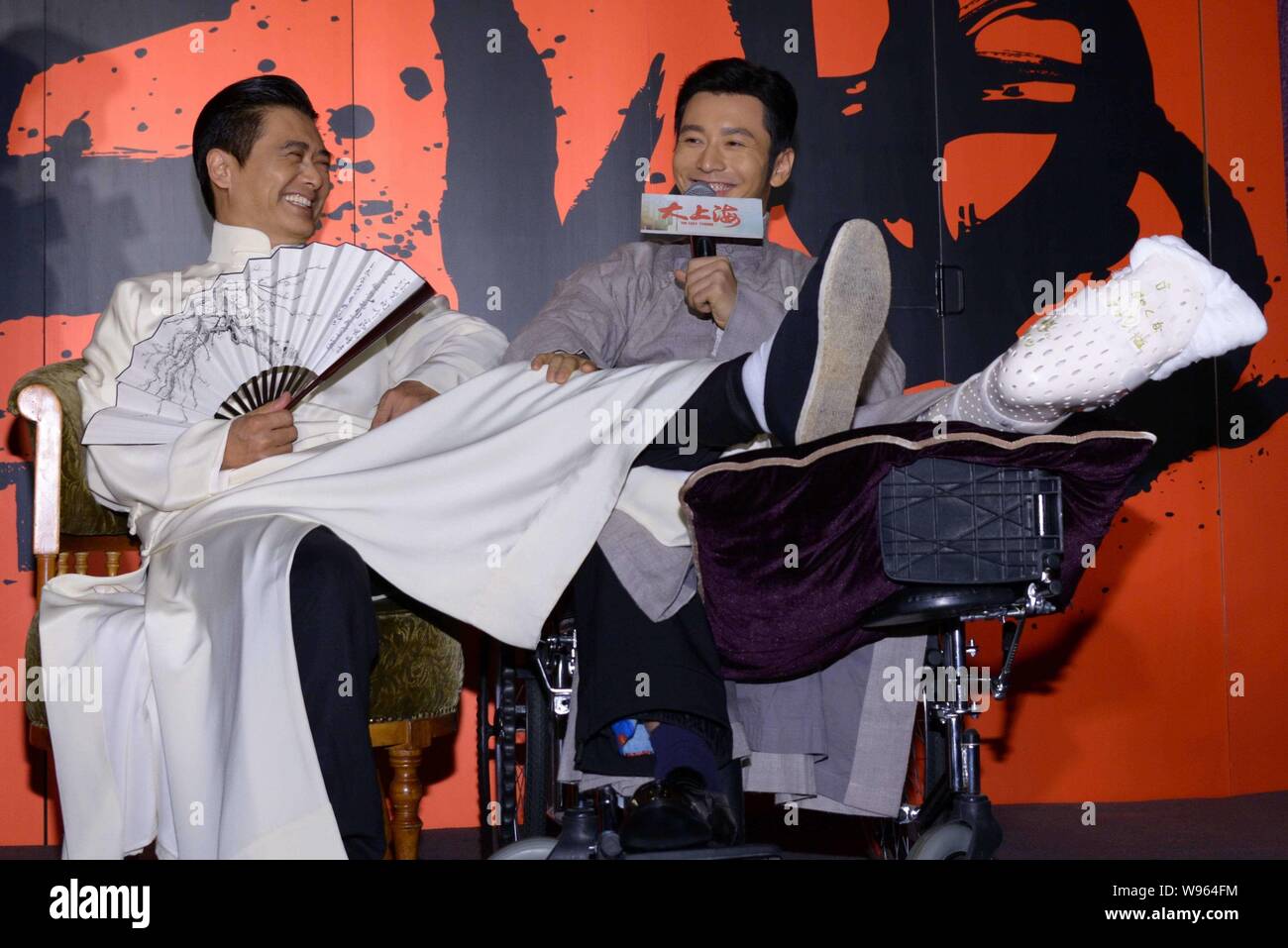 Hong Kong actor Chow Yun-fat, left, and Chinese actor Huang Xiaoming talk and laugh during the press conference for their latest movie, The Last Tycoo Stock Photo