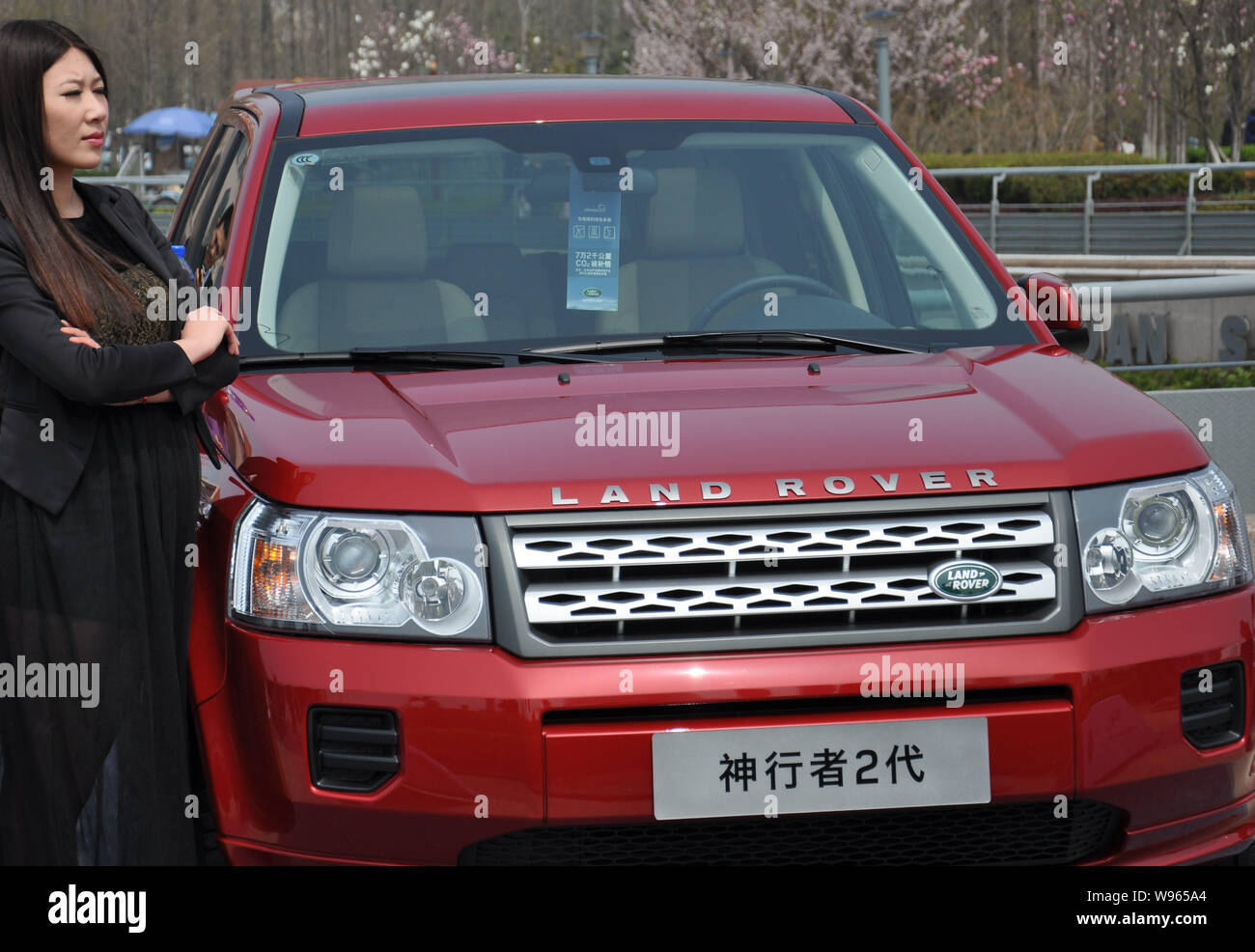 --FILE--A woman poses with a Land Rover Freelander 2 during an auto show in Qingdao city, east Chinas Shandong province, 22 April 2012.   Chery Automo Stock Photo