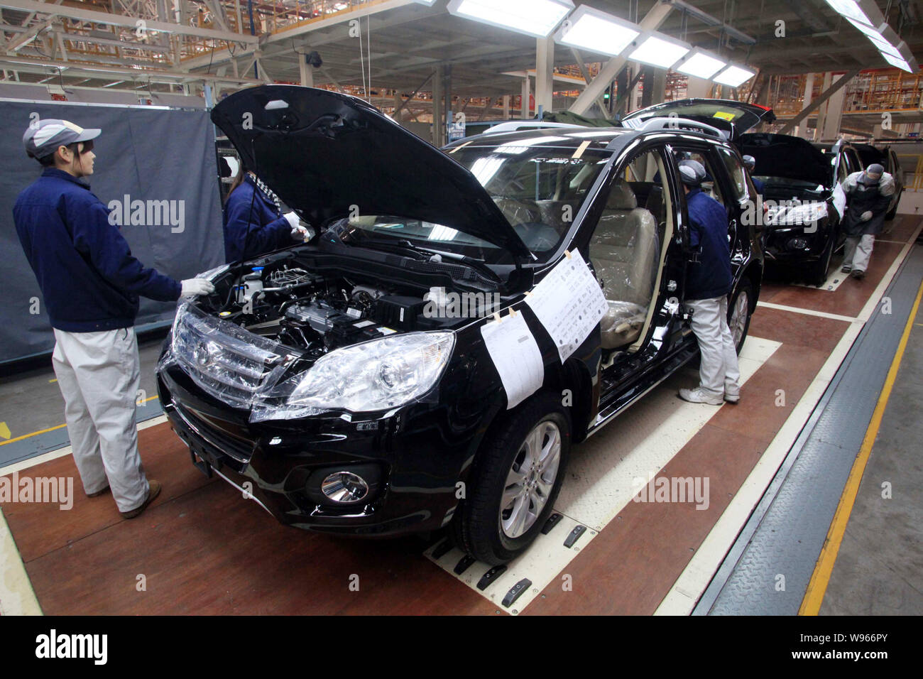 --FILE--Chinese factory workers assemble SUVs on the assembly line at ...