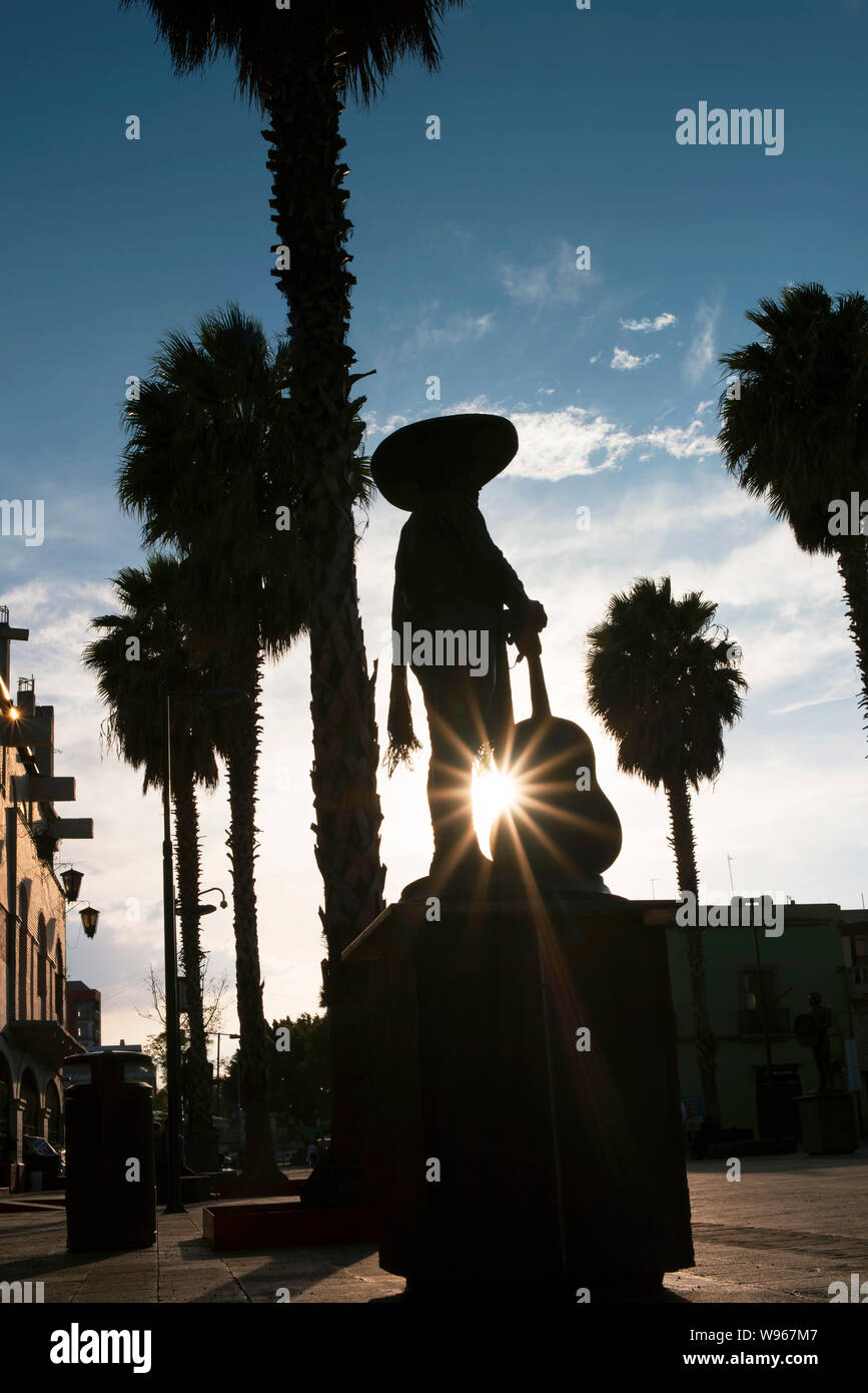 Beautiful silhouette capture of palm trees and Mariachi statue. Garibaldi Square (Plaza Garibaldi), Mexico City, CDMX, Mexico. Jun 2019 Stock Photo
