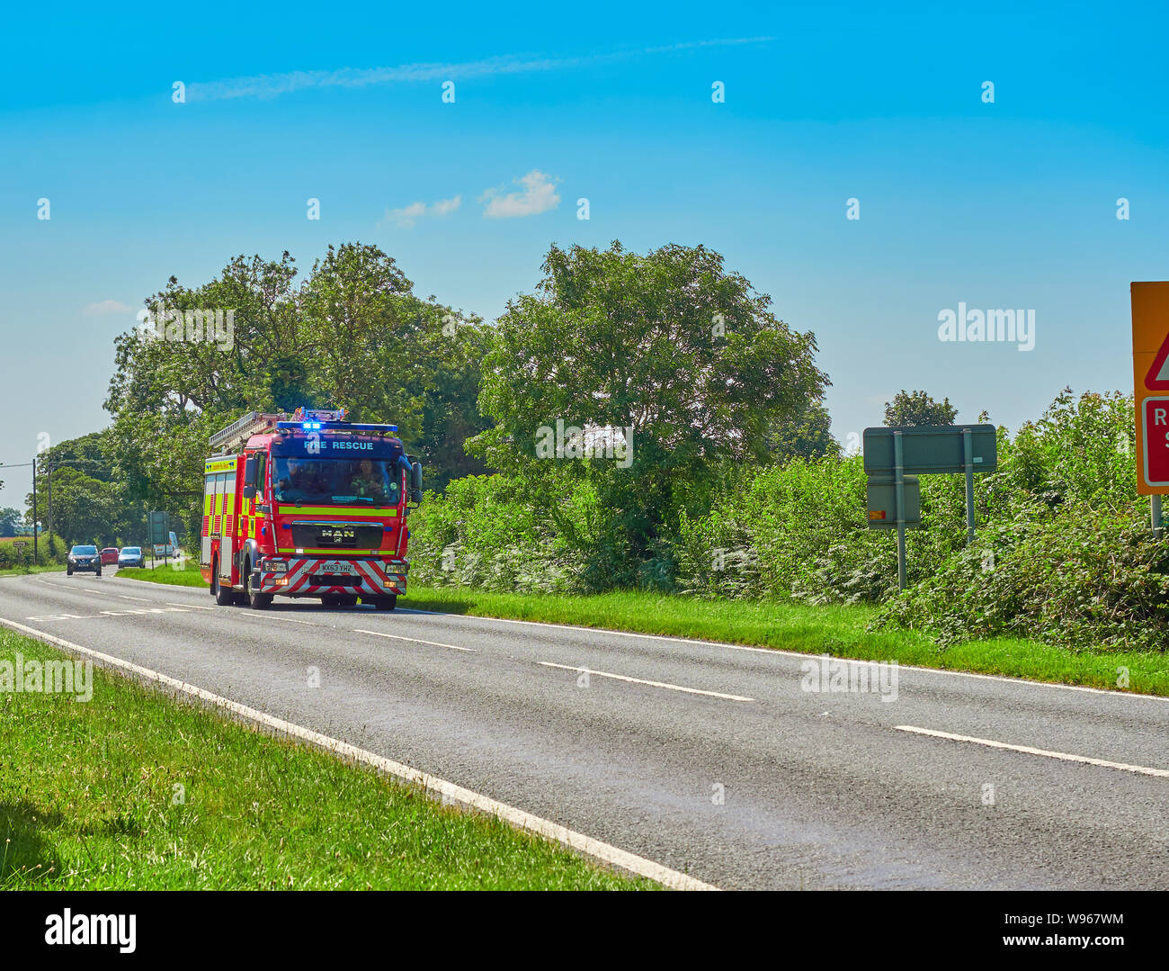 A fire engine from Lincolnshire Fire and Rescue fire brigade racing down the A52 near Ropsley in Lincolnshire under blue light conditions Stock Photo