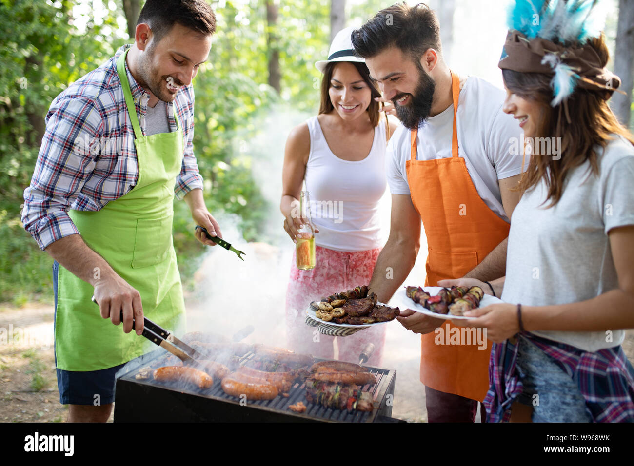 Group of happy friends having a barbecue party in nature Stock Photo ...