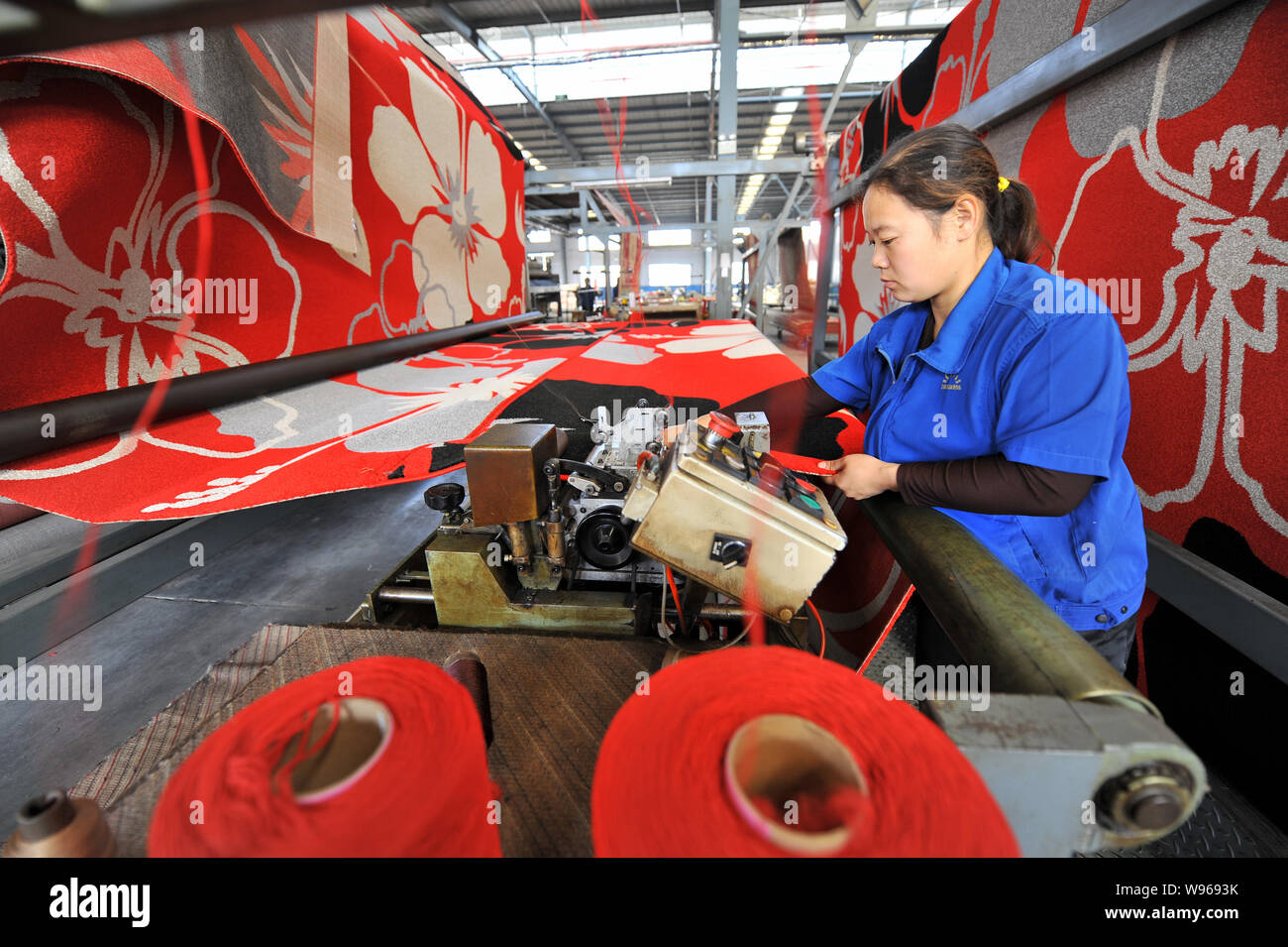 A female Chinese worker makes carpets at a factory in Rizhao city, east Chinas Shandong province, 31 October 2012.   Reuters reported that Chinas offi Stock Photo