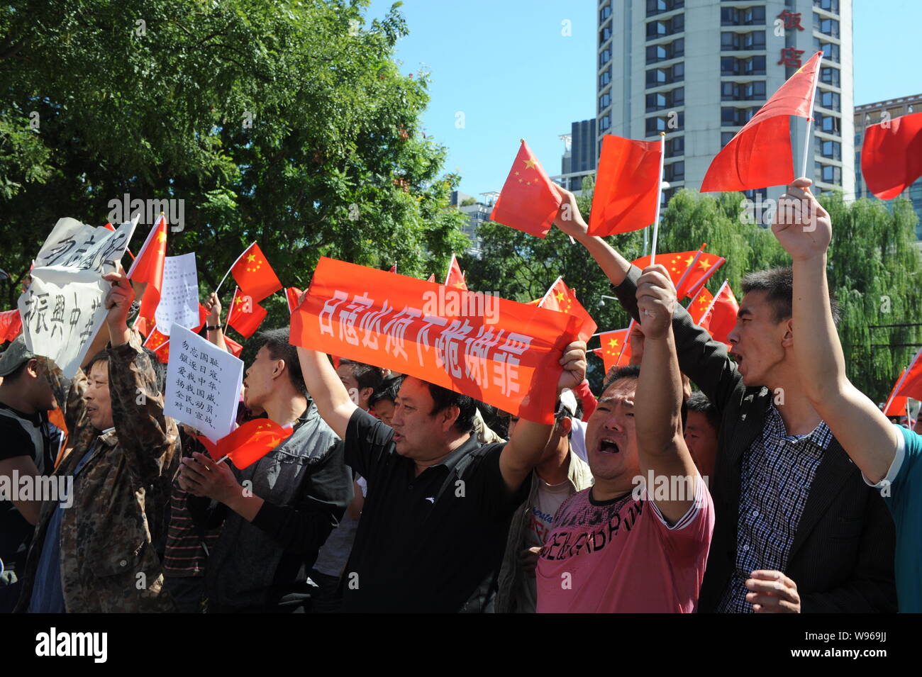 Chinese protestors wave Chinese national flags, hold up banners and ...