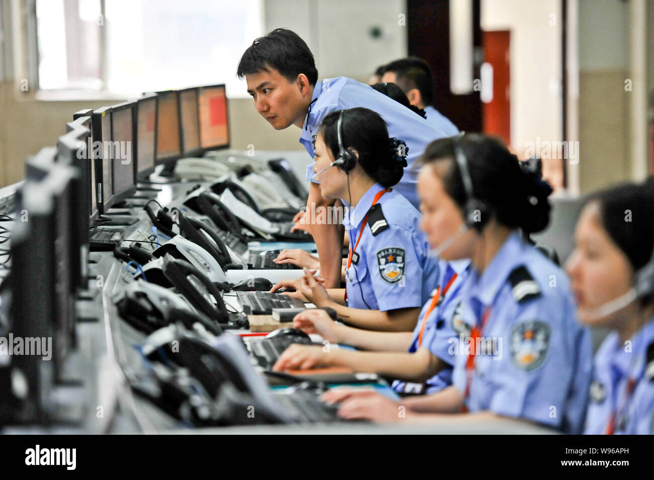 Chinese police officers monitor traffic for the students on their way to schools to take part in the National College Entrance Exam, also known as Gao Stock Photo