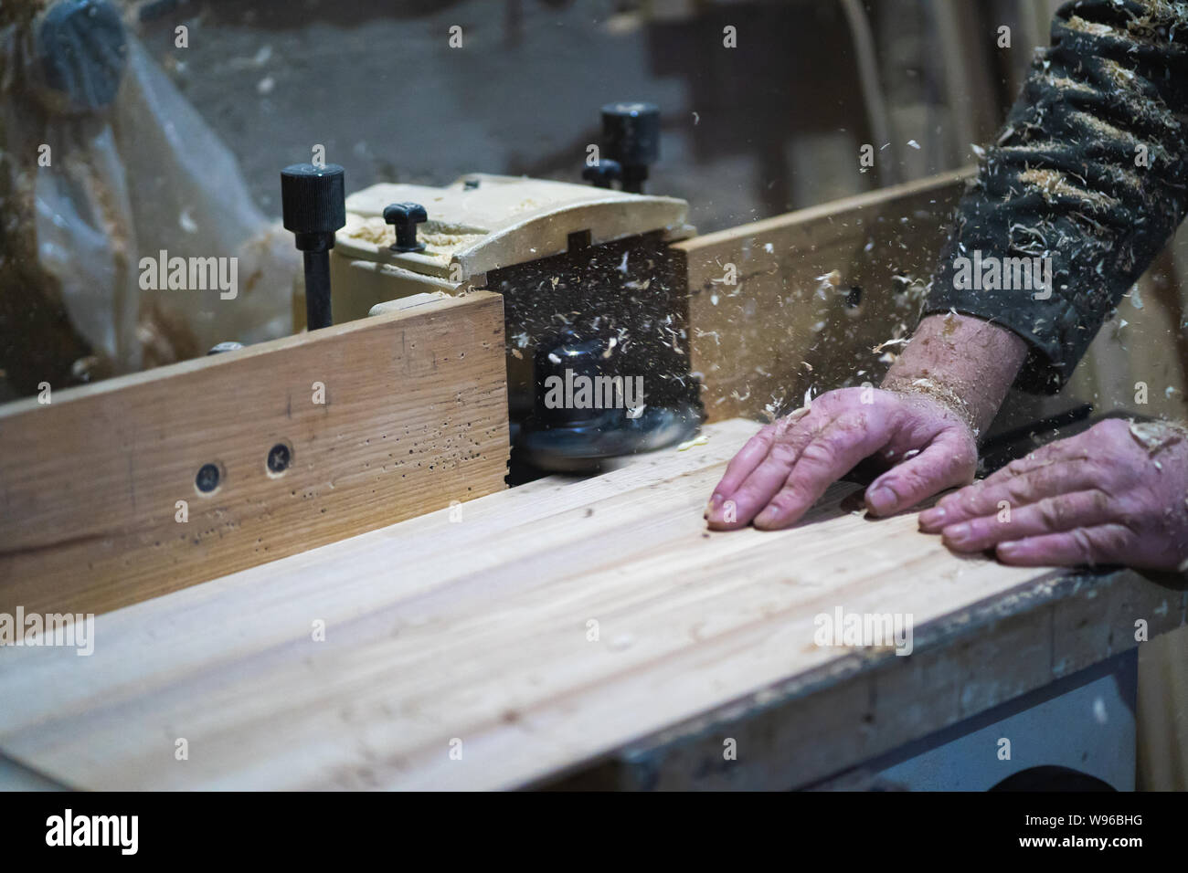 A man is working with wood on milling machine Stock Photo