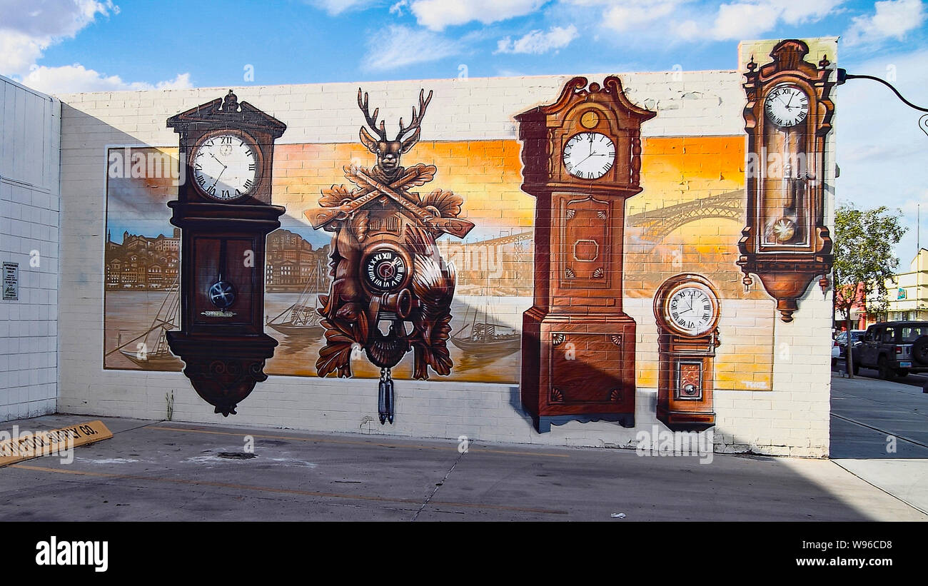 Urban wall clock painted on the corner of the wall in downtown Las Vegas, Nevada, USA. Creating the surrealistic illusion of time and space. Stock Photo