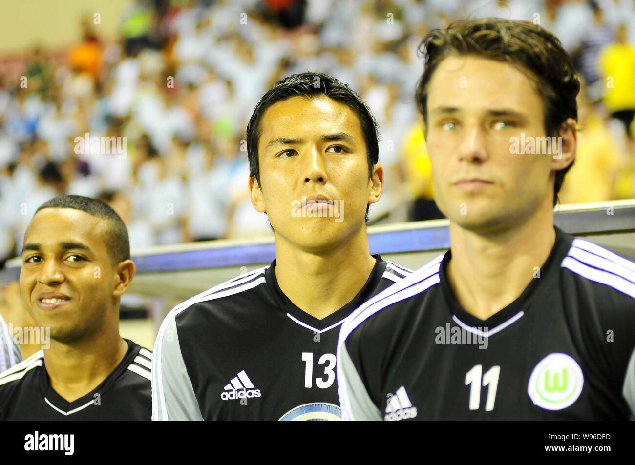 Makoto Hasebe, center, and teammates of VfL Wolfsburg look on during a friendly soccer match against Shanghai Shenxin in Shanghai, China, 29 July 2012 Stock Photo