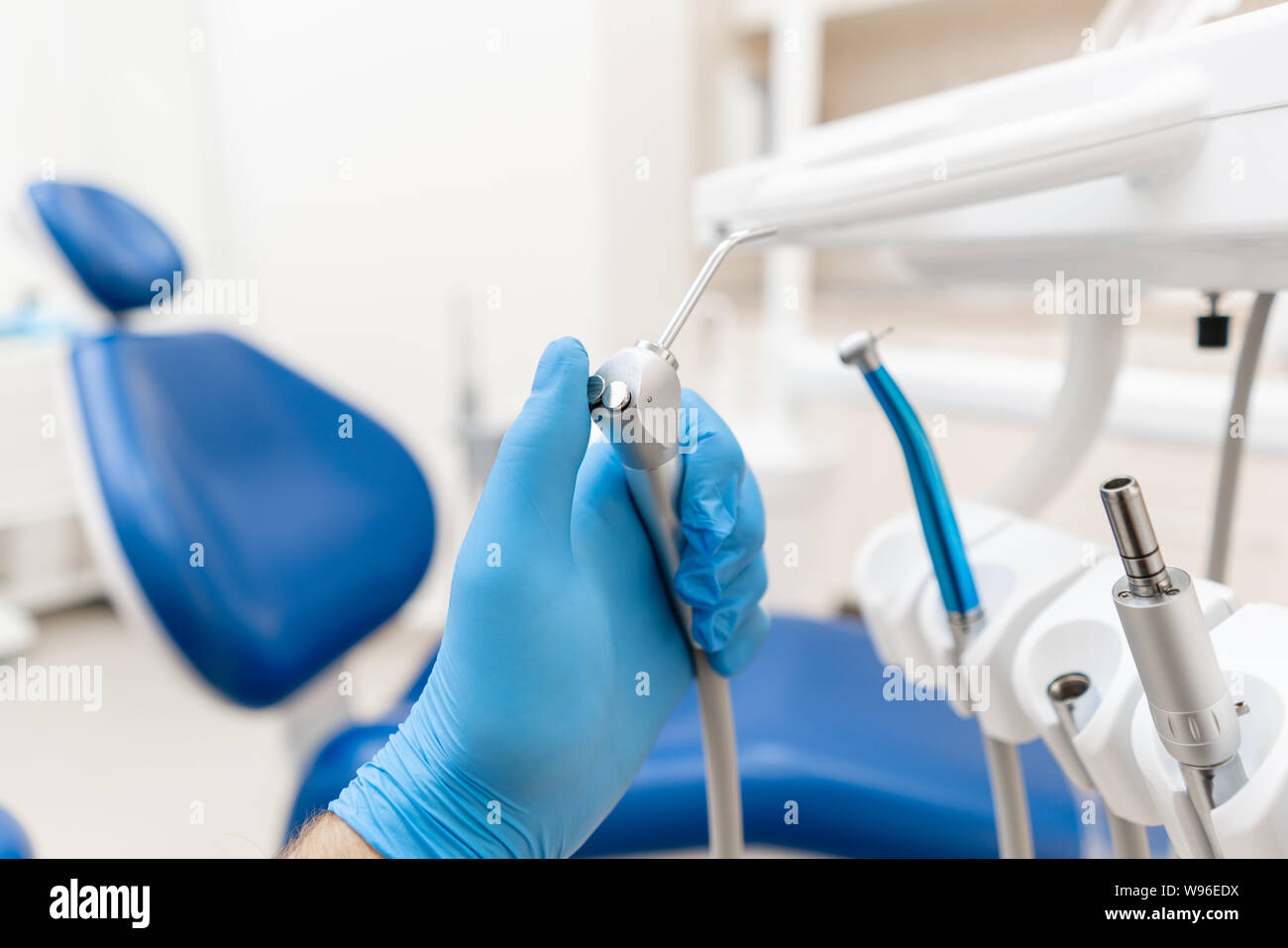 Closeup hand of dentist in the glove holds Gun dental water and air