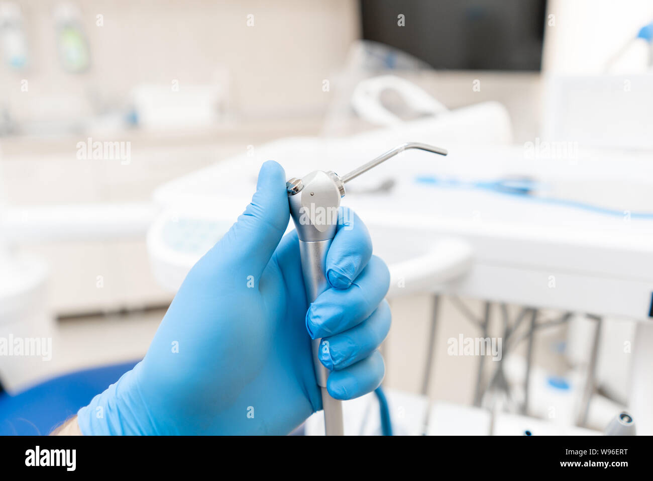 Closeup hand of dentist in the glove holds Gun dental water and air