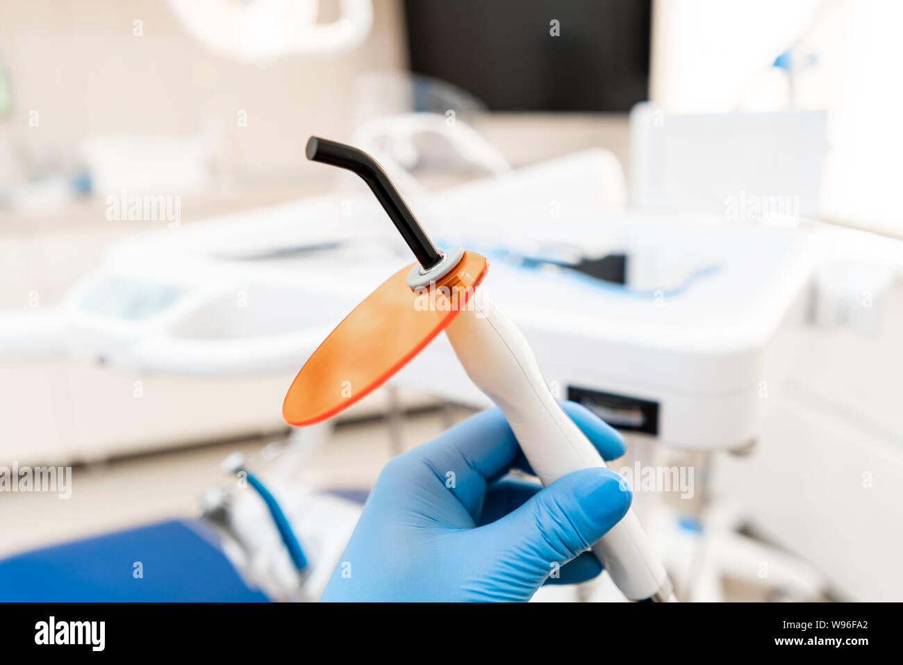 Dental polymerization lamp in dentist hand, with UV light and laser