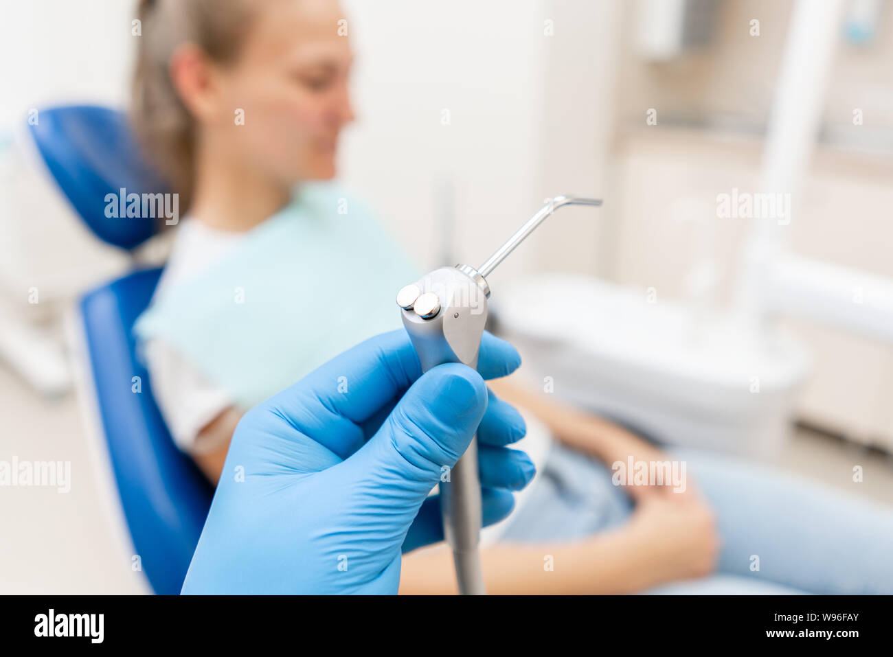 Closeup hand of dentist in the glove holds Gun dental water and air
