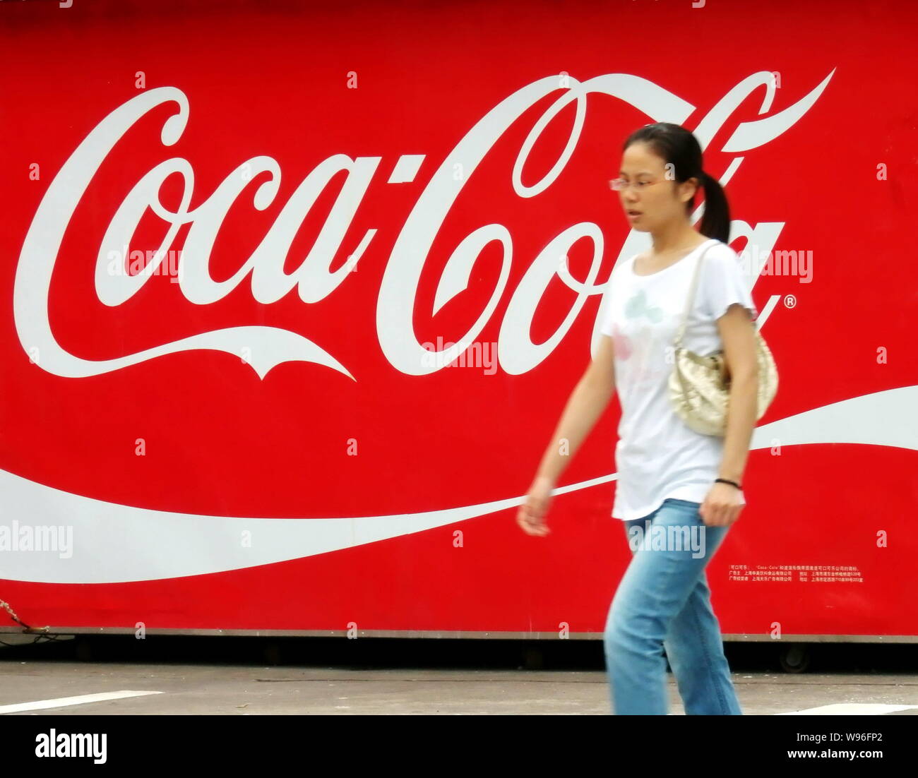 --File--A pedestrian walks past an advertisement of Coca-Cola in ...