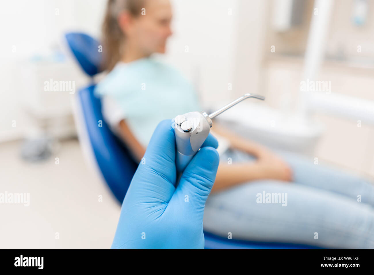 Closeup hand of dentist in the glove holds Gun dental water and air