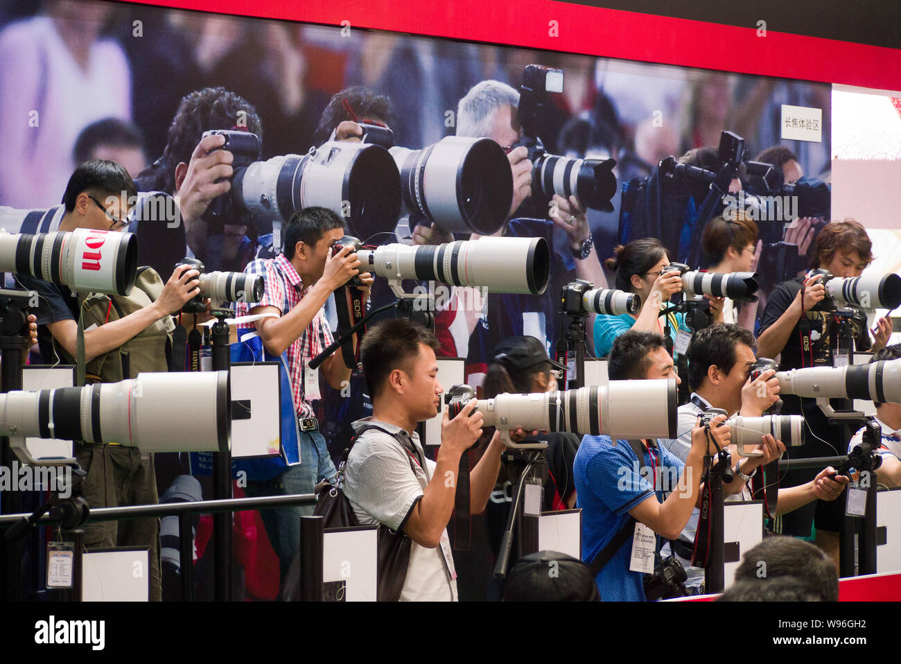 Visitors try out pro cameras at the stand of Canon