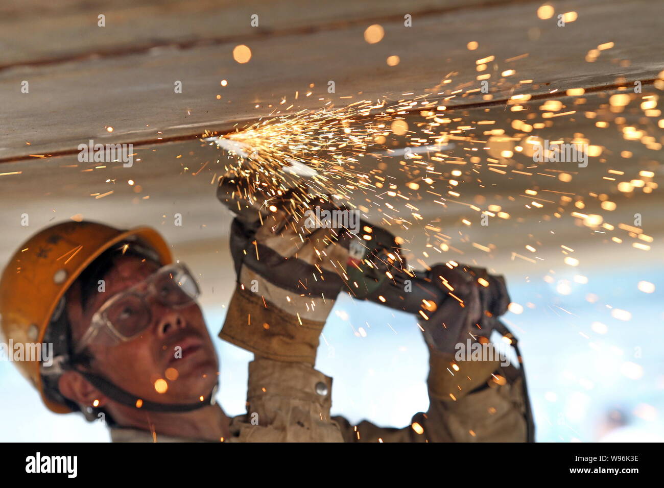 --FILE--A Chinese worker welds a fishing boat at a shipyard in Nantong city, east Chinas Jiangsu province, 28 April 2012.   Chinas economy grew 7.6 pe Stock Photo