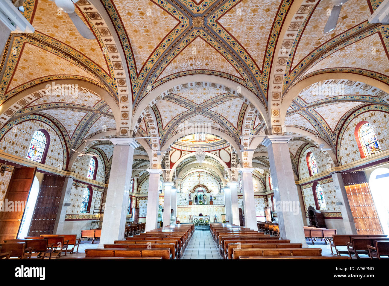 Interior view of the Basilica of Our Lady of Mount Carmel Catholic Church in Catemaco, Veracruz, Mexico. The town is built along a tropical freshwater lake at the center of the Sierra de Los Tuxtlas mountains, is a popular tourist destination and known for free ranging monkeys, the rainforest backdrop and Mexican witches known as Brujos. Stock Photo