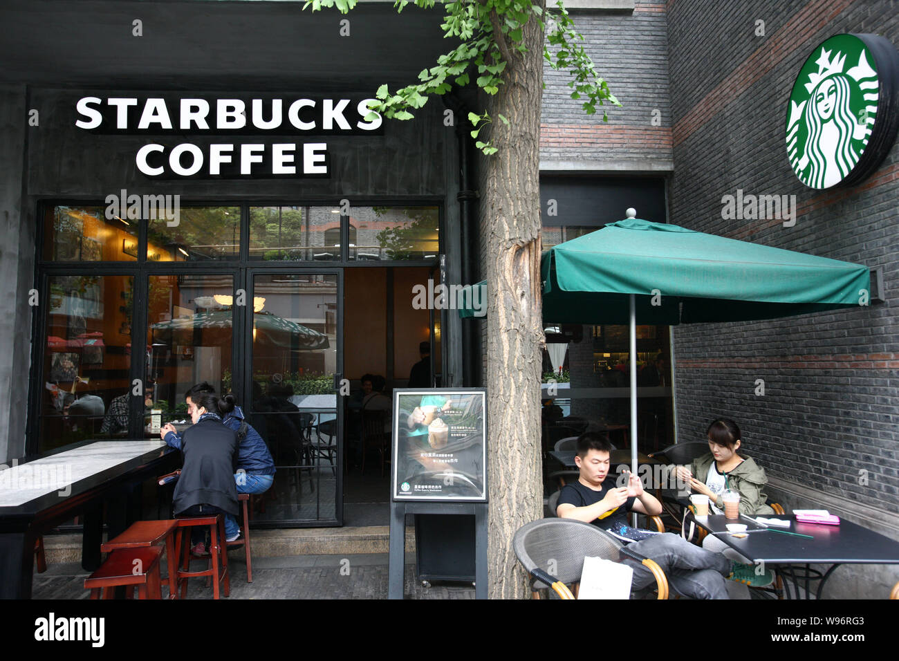 FILECustomers enjoy coffee at a cafe of Starbucks Coffee in Xintiandi, a tourist attraction