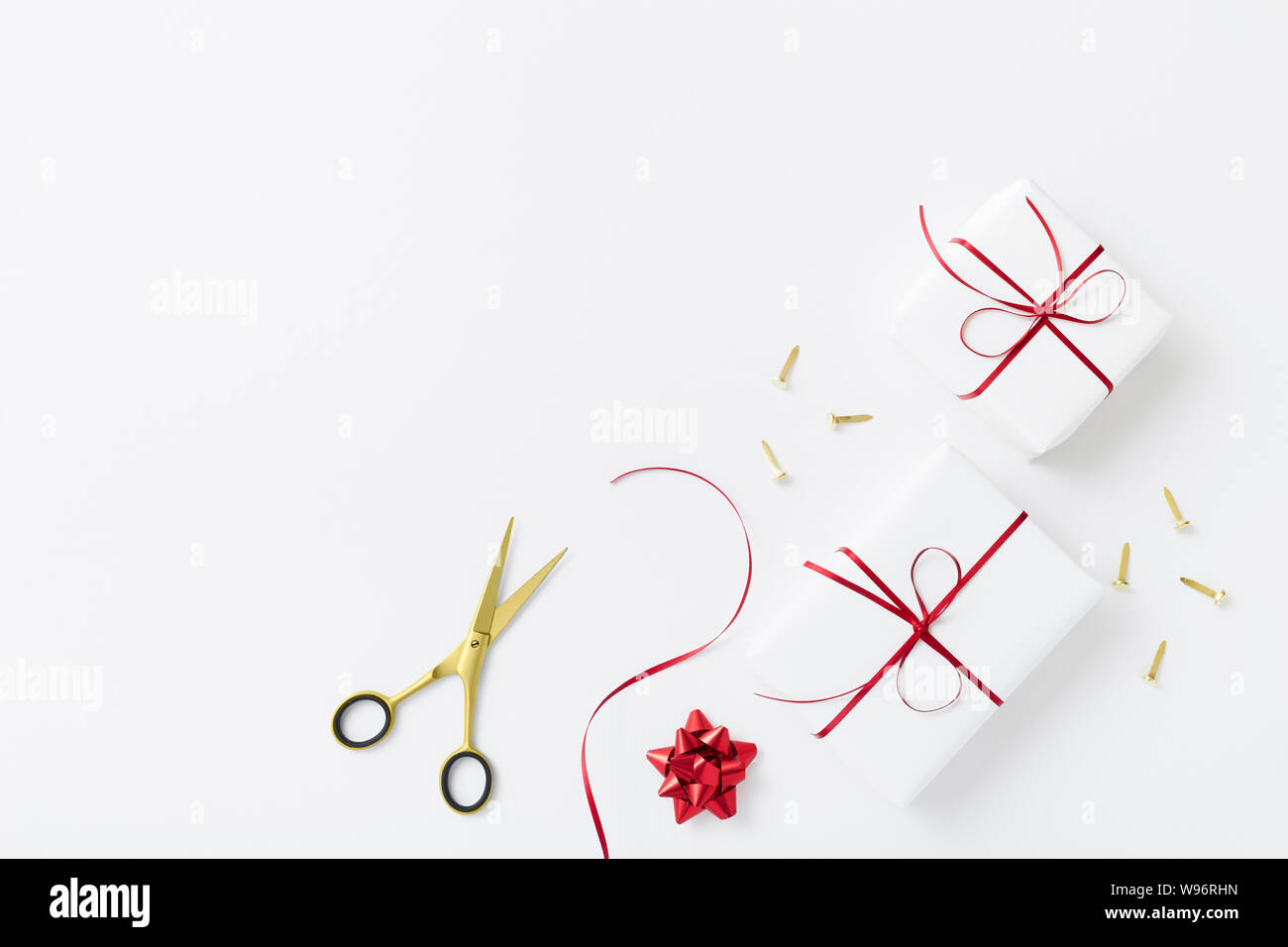 White gift wrapping flat lay with white gifts and red ribbon Stock
