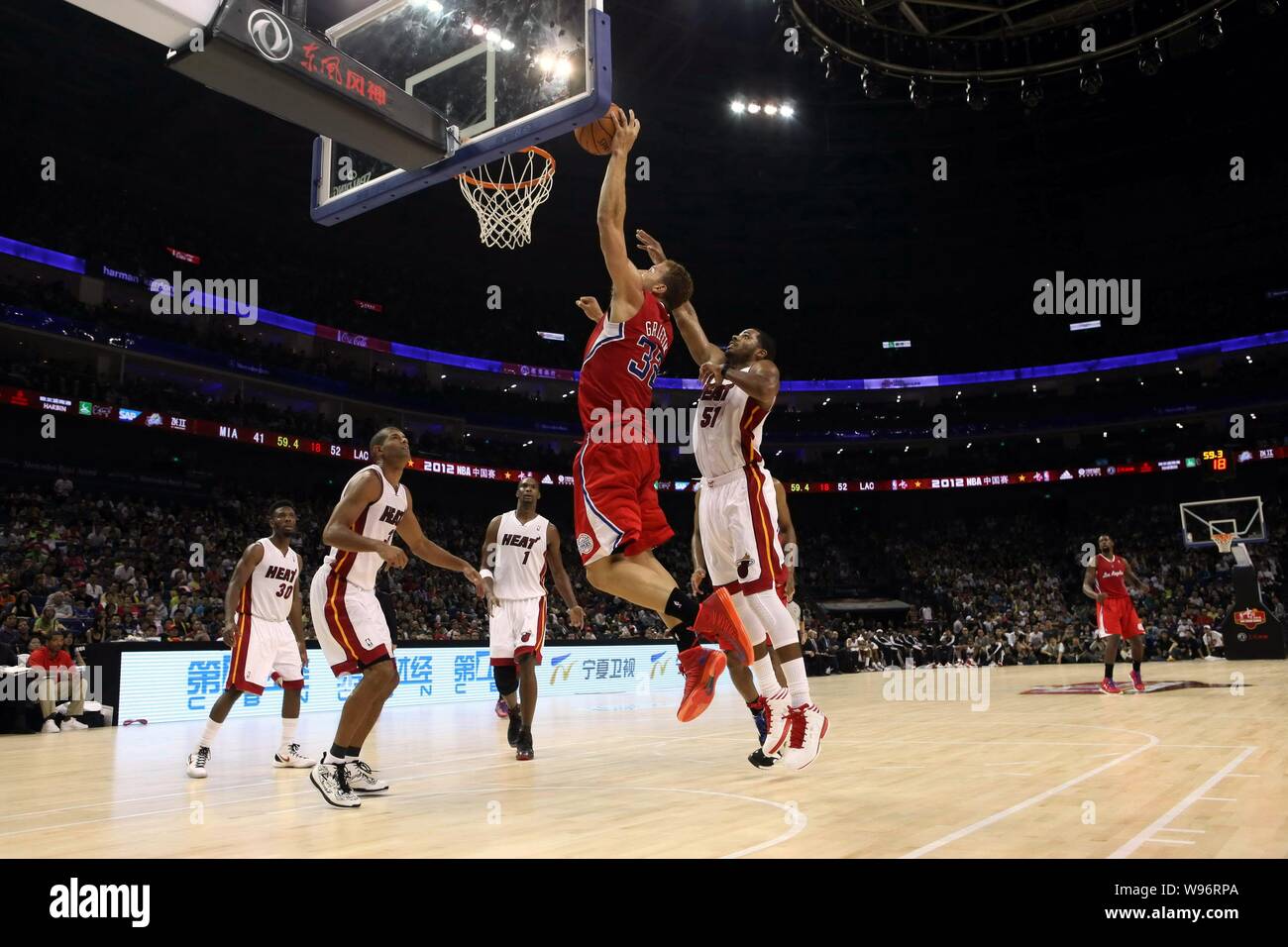 Blake Griffin of the Los Angeles Clippers, top, jumps to dunk against the Miami Heat during their second match of their NBA China Games in Shanghai, C Stock Photo