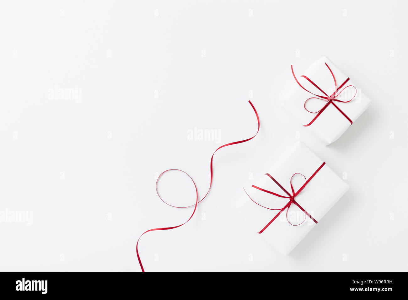White gifts wrapped with red ribbon on white background Stock Photo